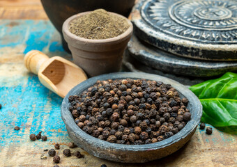 Indian spices collection, dried black peppercorns and another spices in clay bowls
