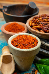 Colorful ground spicy chili peppers , pimento and curcuma is clay pots close up