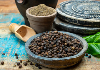 Indian spices collection, dried black peppercorns and another spices in clay bowls