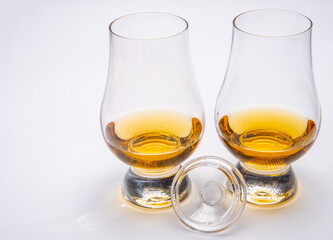 Tulip-shaped tasting glasses with dram of Scotch single malt or blended whisky on white background