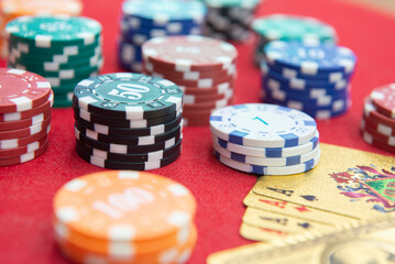 Four of aces near stacks of chips on a red felt table