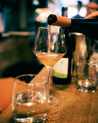Orange wine being poured in a dimly lit environment.