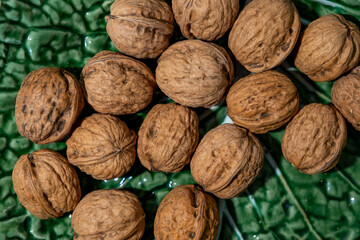 Close up to several Walnut's, Nuts in a green traditional earthenware bowl.