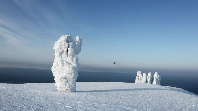 Snow covered stone blocks and white valley. Clip. Aerial view of Manpupuner in winter.