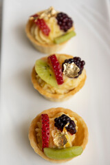 studio, gourmet food served on a plate decorated with tropical fruits and cream, cake as an appetizer