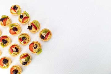 delicious cupcakes with cream and fruits as decoration arranged in the shape of a triangle, studio details, gourmet food with a white background, pastry wallpaper
