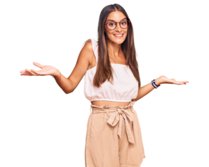 Young hispanic woman wearing casual clothes and glasses smiling showing both hands open palms, presenting and advertising comparison and balance