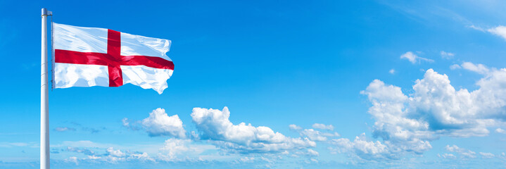 England flag waving on a blue sky in beautiful clouds - Horizontal banner
