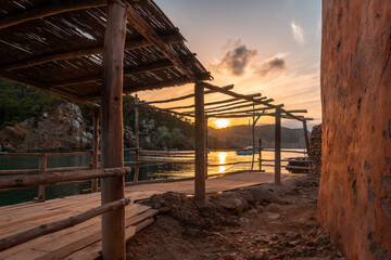 Fototapeta na wymiar Wooden structure in the beach houses at sunset in Benirras in Ibiza. vacation concept
