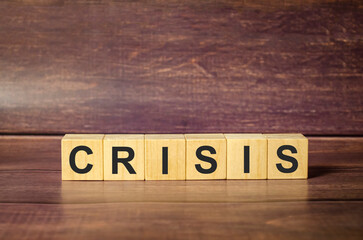 word crisis on wooden blocks and wooden background