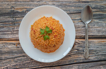 Traditional turkish bulgur pilaf with tomato sause in plate (Turkish name; meyhane pilavi)