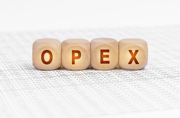 On the table with documents are wooden cubes with the inscription - OPEX