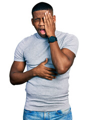 Young black man wearing casual t shirt yawning tired covering half face, eye and mouth with hand. face hurts in pain.