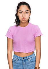 Obraz premium Hispanic teenager girl with dental braces wearing casual clothes puffing cheeks with funny face. mouth inflated with air, crazy expression.