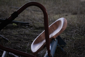 Old, faded, and abandoned playground whirligig seat 