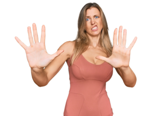 Beautiful caucasian woman wearing casual clothes afraid and terrified with fear expression stop gesture with hands, shouting in shock. panic concept.