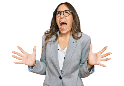 Young brunette woman wearing business clothes crazy and mad shouting and yelling with aggressive expression and arms raised. frustration concept.