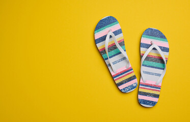 Summer slippers slates on a yellow background, top view
