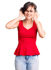 Beautiful young woman with short hair wearing casual style with sleeveless shirt trying to hear both hands on ear gesture, curious for gossip. hearing problem, deaf