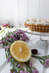 delicious cake with flamed pastry cream as decoration, on the table is a natural flower and a slice of fresh lemon, cooking ingredients