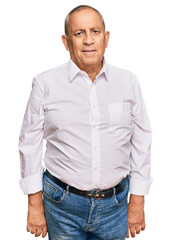 Handsome senior man wearing elegant white shirt relaxed with serious expression on face. simple and...