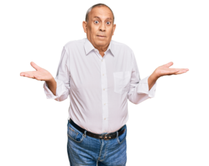 Handsome senior man wearing elegant white shirt clueless and confused expression with arms and hands raised. doubt concept.