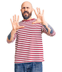 Young handsome man wearing casual clothes afraid and terrified with fear expression stop gesture with hands, shouting in shock. panic concept.