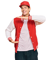 Handsome caucasian man wearing baseball uniform gesturing with hands showing big and large size sign, measure symbol. smiling looking at the camera. measuring concept.