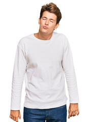 Fototapeta premium Handsome caucasian man wearing casual white sweater looking at the camera blowing a kiss on air being lovely and sexy. love expression.