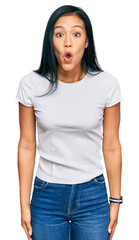 Obraz premium Beautiful hispanic woman wearing casual white tshirt afraid and shocked with surprise and amazed expression, fear and excited face.