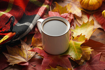 Two white cups with black coffee in a cozy autumn setting with red, yellow and orange leaves, hokkaido pumpkins, on wooden background