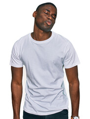 Young african american man wearing casual white t shirt looking at the camera blowing a kiss on air being lovely and sexy. love expression.