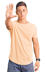Young handsome man wearing casual clothes doing stop sing with palm of the hand. warning expression...