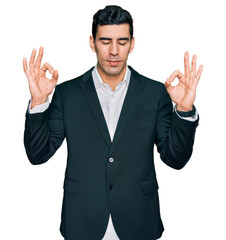 Handsome hispanic man wearing business clothes relaxed and smiling with eyes closed doing meditation gesture with fingers. yoga concept.