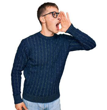 Young blond man wearing casual clothes and glasses shouting and screaming loud to side with hand on mouth. communication concept.