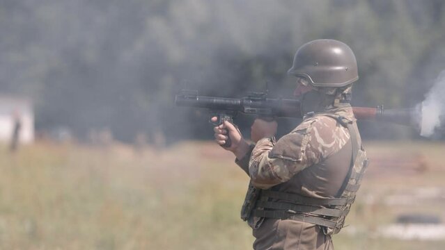 Soldier in uniform, helmet, and body armor fire Precision Shoulder-Fired Rocket Launchers RPG-7 PSRL-1 at the enemies.