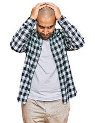 Hispanic adult man wearing casual clothes suffering from headache desperate and stressed because pain and migraine. hands on head.