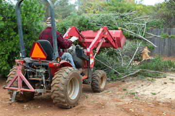 Man Working on Tractor Clearing Brush