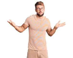 Young caucasian man wearing casual clothes and glasses clueless and confused expression with arms and hands raised. doubt concept.
