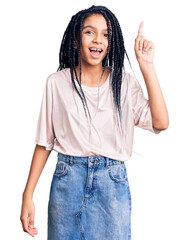 Cute african american girl wearing casual clothes pointing finger up with successful idea. exited and happy. number one.