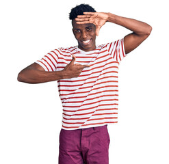 Young african american man wearing casual clothes smiling making frame with hands and fingers with happy face. creativity and photography concept.