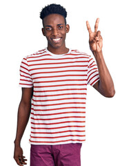 Naklejka premium Young african american man wearing casual clothes showing and pointing up with fingers number two while smiling confident and happy.