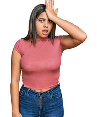 Obraz premium Young hispanic girl wearing casual t shirt surprised with hand on head for mistake, remember error. forgot, bad memory concept.