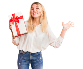 Young beautiful blonde woman holding gift annoyed and frustrated shouting with anger, yelling crazy with anger and hand raised