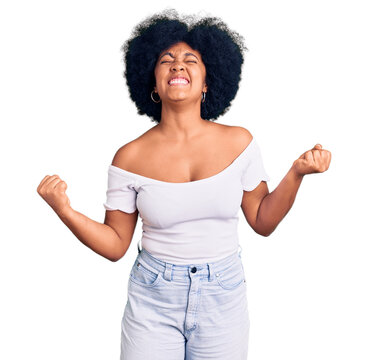 Young african american girl wearing casual clothes very happy and excited doing winner gesture with arms raised, smiling and screaming for success. celebration concept.