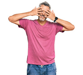 Fototapeta premium Middle age grey-haired man wearing casual clothes covering eyes with hands smiling cheerful and funny. blind concept.