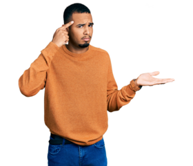 Young african american man wearing casual clothes confused and annoyed with open palm showing copy space and pointing finger to forehead. think about it.