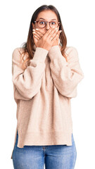 Beautiful caucasian woman wearing wool winter sweater shocked covering mouth with hands for mistake. secret concept.