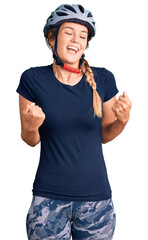 Beautiful caucasian woman wearing bike helmet very happy and excited doing winner gesture with arms raised, smiling and screaming for success. celebration concept.