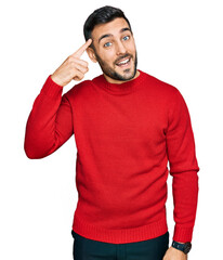 Young hispanic man wearing casual clothes smiling pointing to head with one finger, great idea or thought, good memory